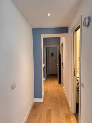 an empty hallway with blue walls and wooden floors at Residenza Labicana few steps from Colosseum in Rome