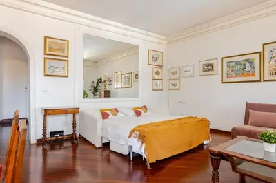 a white bedroom with a bed and a couch at Urbanflat Colosseum in Rome