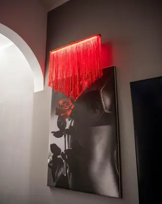 a picture of a woman with a red lamp on a wall at Suite Tacco 12 in Rome
