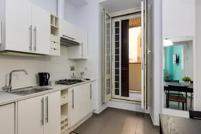 a kitchen with white cabinets and a sink at Aurora Vatican House - San Pietro in Rome