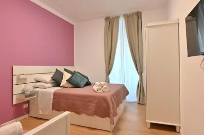 a bedroom with a bed and a purple wall at Jubilee 4 Your home in Rome Vatican in Rome