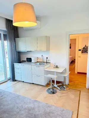 a kitchen with white cabinets and a sink and a table at Civico3 in Città Piazza del Popolo in Rome