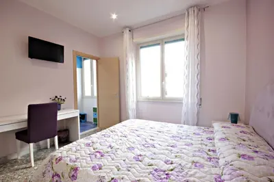 a bedroom with a bed and a desk and a window at B&B Clelia in Rome