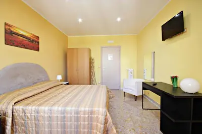 a hotel room with a bed and a desk and a television at B&B Clelia in Rome