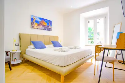 a bedroom with a large white bed with blue pillows at Elegantis Gracchi Apartment - Your Chic Retreat in Central Rome - Vatican Area in Rome