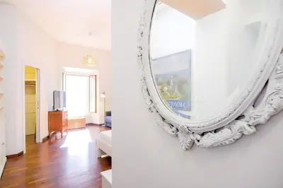 a living room with a mirror on the wall at Elegantis Veniero Suite Apartment - 1 Minute Walk to Vatican Museums in Rome