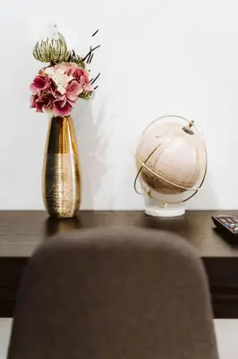 a vase with flowers and a globe on a table at Michelangelo Luxury Rooms - Colosseo - WiFi in Rome
