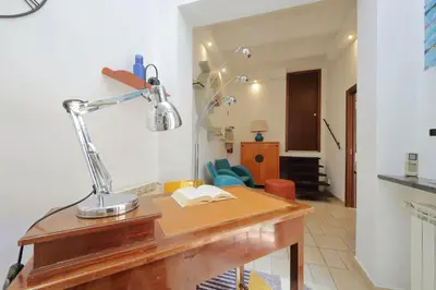 a desk with a lamp and a book on it at Rifugio segreto nel cuore di Roma in Rome