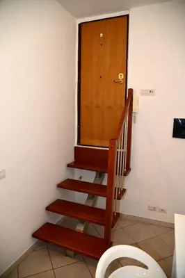 a staircase with a wooden door and a toilet at Stefy's House Appio Tuscolano in Rome