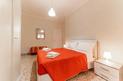 a bedroom with a bed with an orange blanket at Vacanze Romane - Metro Teano & Wi-Fi in Rome