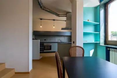 a kitchen with a black table and chairs at Livin' San Lorenzo in Rome