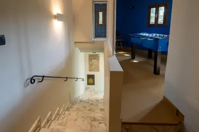 a hallway with blue walls and a staircase with a tile floor at Livin' San Lorenzo in Rome