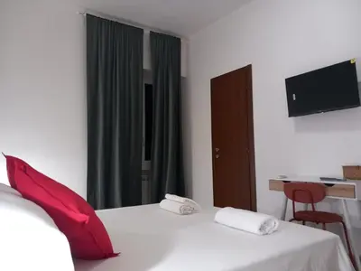 a bedroom with a bed with red pillows and a desk at TravelR's Home in Rome