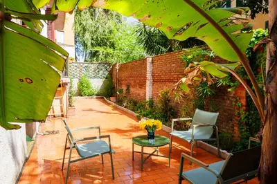 two chairs and a table next to a brick wall at Simi Roma Palombini, Appartamento con Giardino in Rome