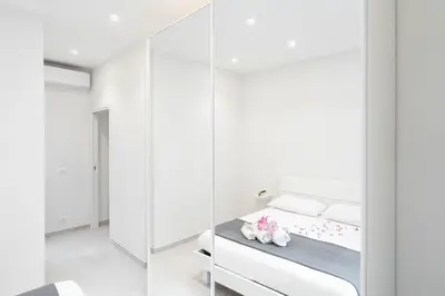 a bedroom with white walls and a bed with white pillows at Domus Aurea2 a stone's throw from the Colosseum in Rome