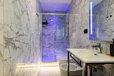 a bathroom with a sink and a shower with purple lighting at Vittorio Emanuele Art Suites in Rome
