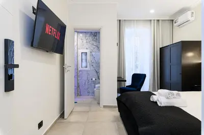 a hotel room with a bed and a bathroom at Vittorio Emanuele Art Suites in Rome