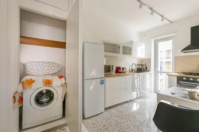 a kitchen with a washing machine and a refrigerator at Casa Leone in Rome