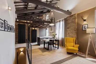 a living room with a table and a yellow chair at Loft Navona in Rome