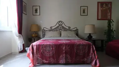 a bedroom with a bed with a red blanket and two lamps at B&B Caput Mundi in Rome