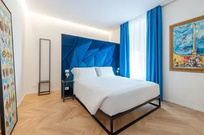 a bedroom with a large bed with a blue headboard at Scipioni 235 Luxury Suite in Rome