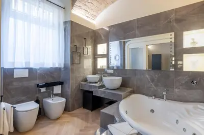 a bathroom with two sinks and a tub and a toilet at Scipioni 235 Luxury Suite in Rome