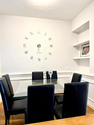 a dining room with a table and a clock on the wall at San Pietro APT near Vatican city Roma in Rome