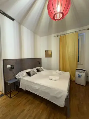 a bedroom with a large bed with a chandelier at Loft in Colosseum, style in the heart of Rome! in Rome