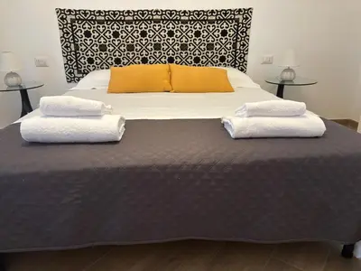 a large bed with two towels on top of it at San Peter-Vatican Way in Rome