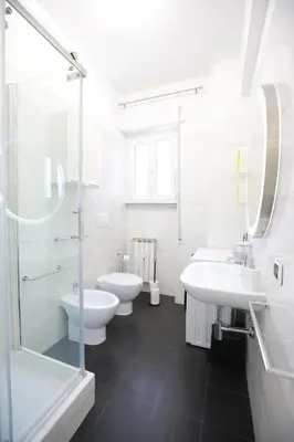 a white bathroom with two sinks and two toilets at Unique Stay Tiburtina in Rome