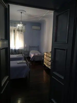 a room with two beds and a chandelier at Around The Corner Colosseo B&B in Rome