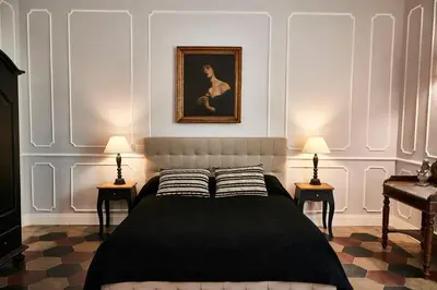 a bedroom with a bed with two lamps and a painting at Ale & Niki's Home in Rome