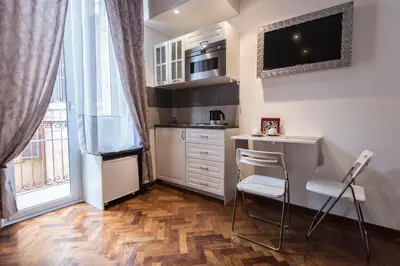 a small kitchen with a desk and a tv on the wall at Vite Suites Guest House in Rome