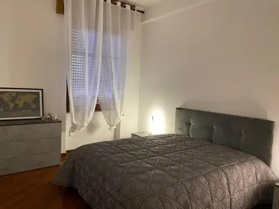 a bedroom with a bed and two windows at La Casa di Ester Three-room apartment in Rome