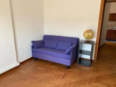 a purple couch in a room with a table at La Casa di Ester Three-room apartment in Rome
