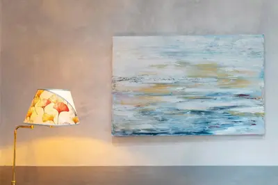 a painting hanging on a wall next to a lamp at RomanticRome, elegant apartment in Trastevere district in Rome