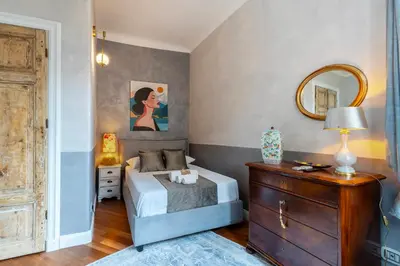 a bedroom with a bed and a dresser and a mirror at RomanticRome, elegant apartment in Trastevere district in Rome