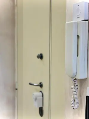 a phone hanging on a wall next to a door at Monti Hideaway - Walk to Colosseum & Forum in Rome