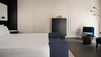 a bedroom with a bed and a blue chair at Casa Guttmann in Rome