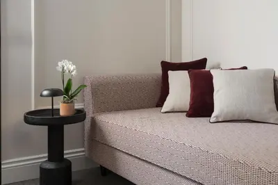 a bed with red pillows and a table with a plant on it at Casa Guttmann in Rome