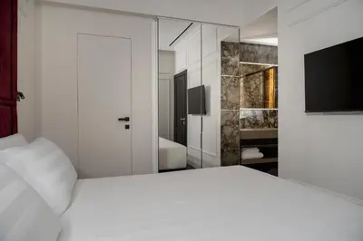 a bedroom with a white bed and a television at Casa Guttmann in Rome