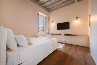 a bedroom with a white bed and a television at Skylife Monti's Wonders - Colosseum Gem in Rome