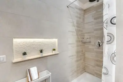 a white bathroom with a shower and a sink at Loft in the Ghetto 2 in Rome
