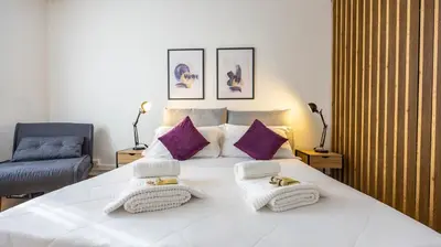 a bedroom with a large white bed with purple pillows at Flat 5 - In San Giovanni by Rentbeat in Rome