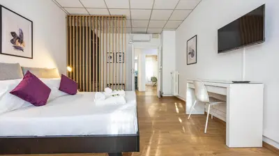 a hotel room with a bed and a desk at Flat 5 - In San Giovanni by Rentbeat in Rome