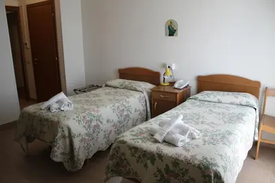 two beds with towels on them in a room at Villa Santa Emerenziana in Rome