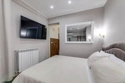 a bedroom with a bed and a flat screen tv at Vogue Suites Rome in Rome