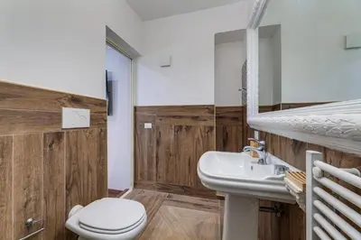 a bathroom with a sink and a toilet and a mirror at Vogue Suites Rome in Rome