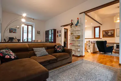 a living room with a brown couch and a kitchen at Villa Classical Roman Art - Monteverde with Garden in Rome