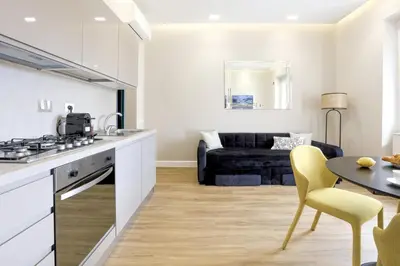 a kitchen and living room with a table and a couch at Easylife - Charme, comfort e quiete vicino Termini in Rome